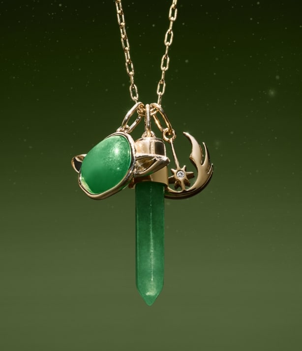Un collier doré avec des charms ayant la forme de Yoda, de sabre laser et du symbole de la Rébellion