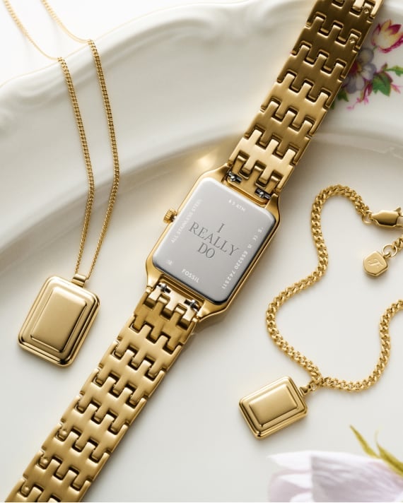 Drei goldfarbene Stücke aus Kollektion Raquel von Fossil, darunter eine Halskette, ein Band und eine Uhr mit einer Gravur auf der Rückseite mit der Aufschrift „I REALLY DO“