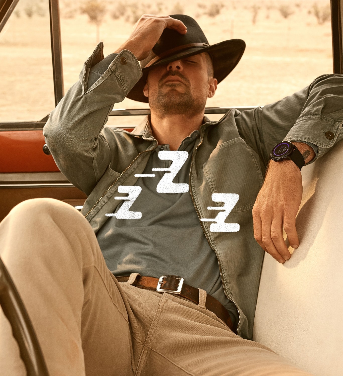 ジェネレーション6スマートウォッチを着けてトラックで昼寝をする帽子の男性。