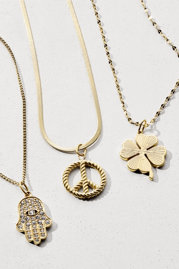 Three gold-tone necklaces with three charms. 
