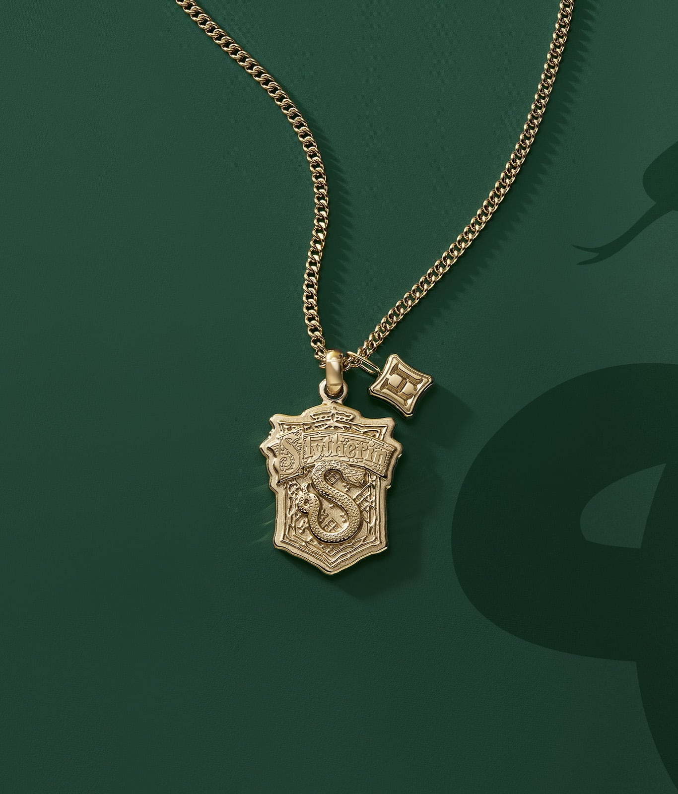 A gold-tone Slytherin house pendant.