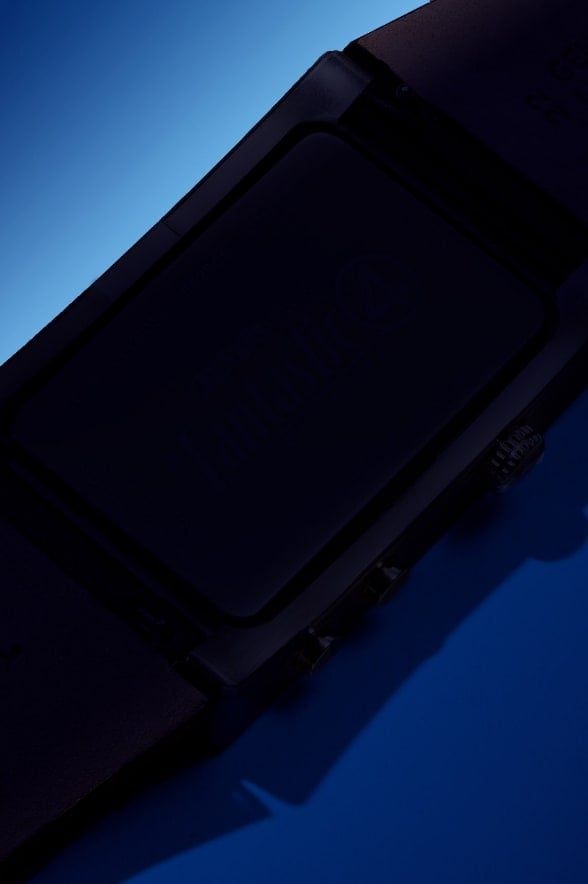 A blurred view of two watches on a dark, intergalactic background.