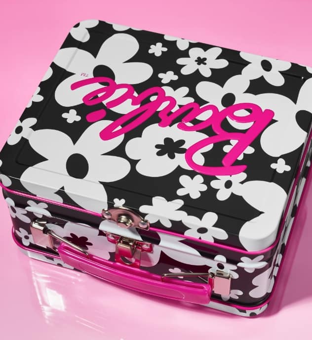 Image one. A lunchbox-inspired Barbie tin featuring a graphic black and white floral print with hot pink accents.