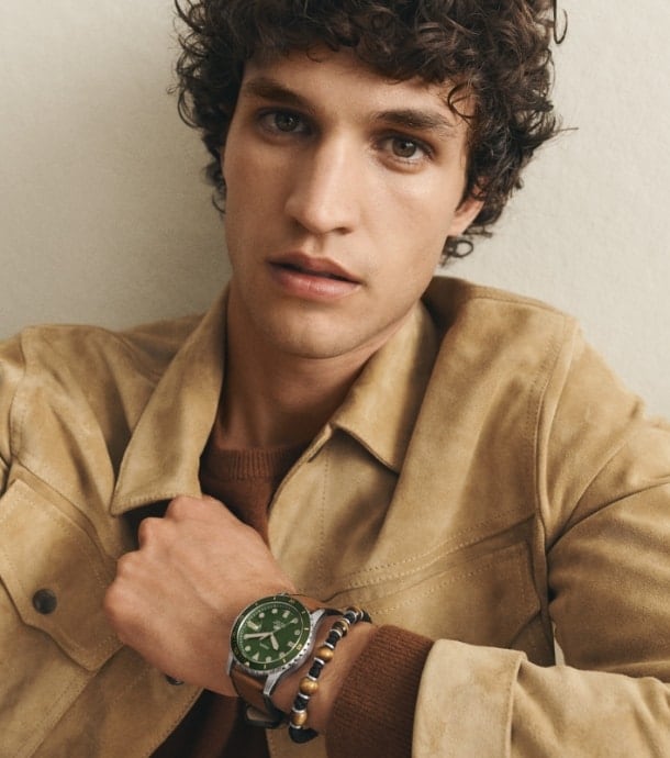 A man wearing the Fossil Blue watch and a beaded leather bracelet. Two men's beaded leather bracelets.