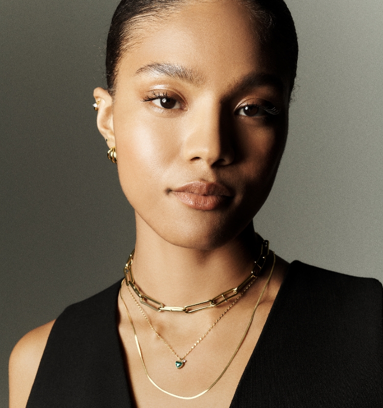 Woman wearing gold-tone Fossil jewellery.