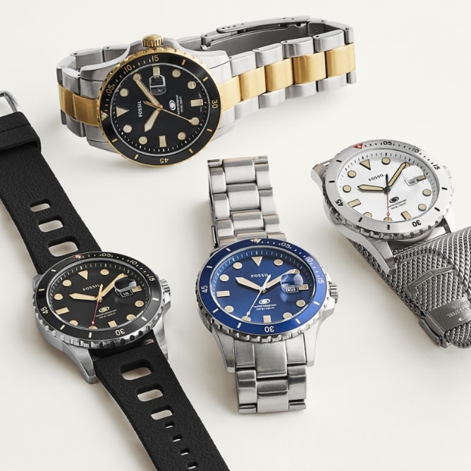 Fotografía de toda la colección de relojes Fossil Blue, que incluye la correa de piel bruñida, una correa de silicona negra, un brazalete de acero liso y una correa de malla inspirada en la cota de malla.