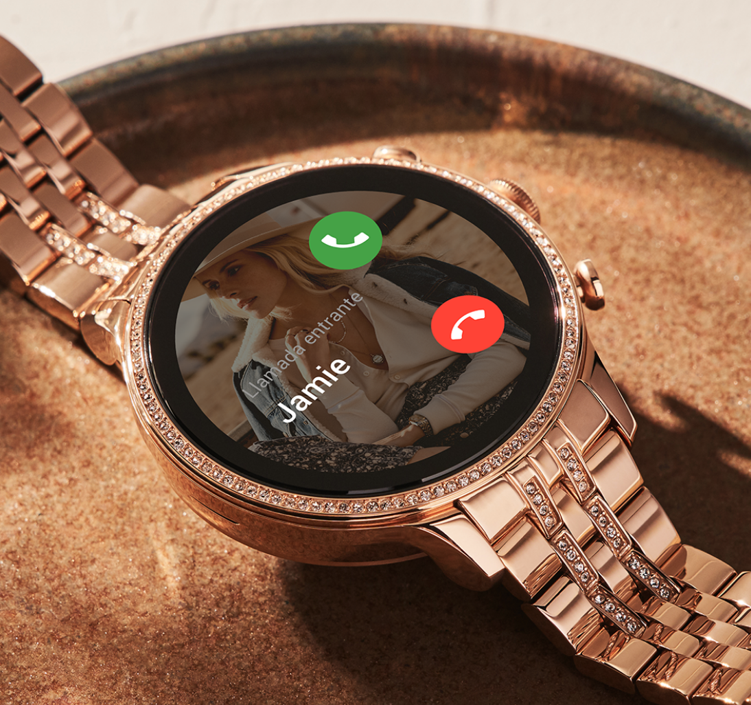 Un smartwatch Gen 6 de acero inoxidable en tono oro rosa con una llamada entrante en la esfera. Un smartwatch Gen 6 de acero inoxidable en tono oro rosa con una llamada entrante en la esfera.