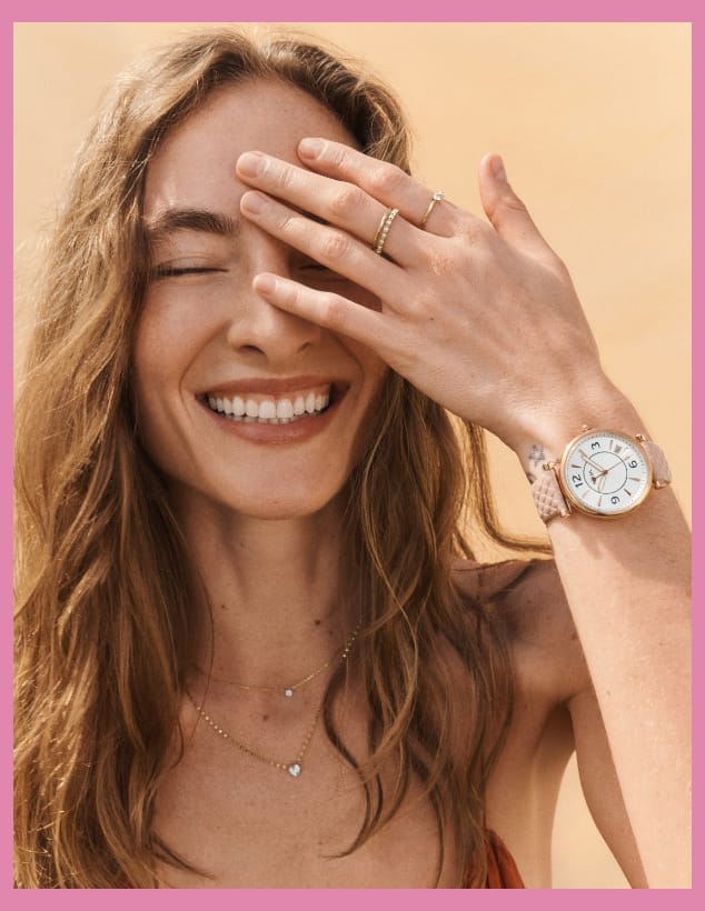 A woman smiling wearing a specially designed Carlie watch with blush strap.