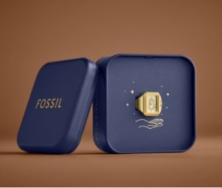 A blue tin with a gold-tone Watch Ring inside.