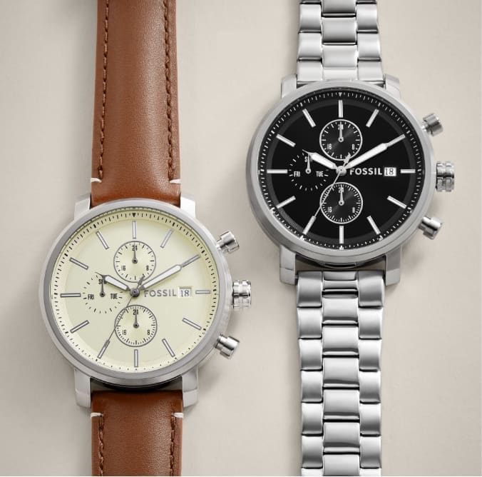 Two men’s watches are shown, both featuring a round dial with a modern face and oversized lugs. The watch on the left has a brown leather strap and cream-coloured dial. The watch on the right features a stainless steel link strap and a dark blue dial.