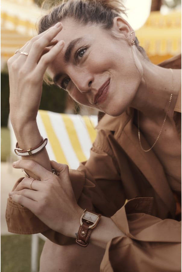 A woman smiling and wearing our Fossil spring jewelry.