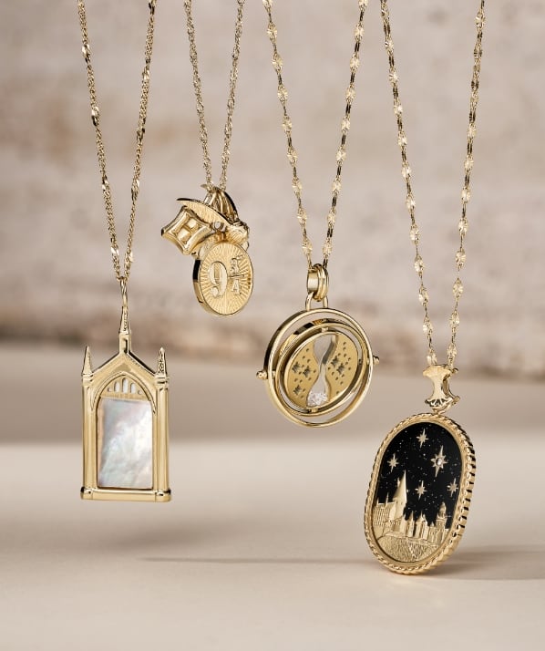 Group shot of gold-tone Mirror of Erised™, Time-Turner™, Hogwarts™ Skyline and Platform 9¾™ necklaces.
