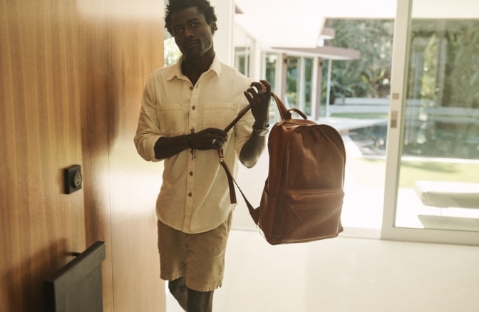 Homme portant un sac à dos Buckner en cuir brun. 