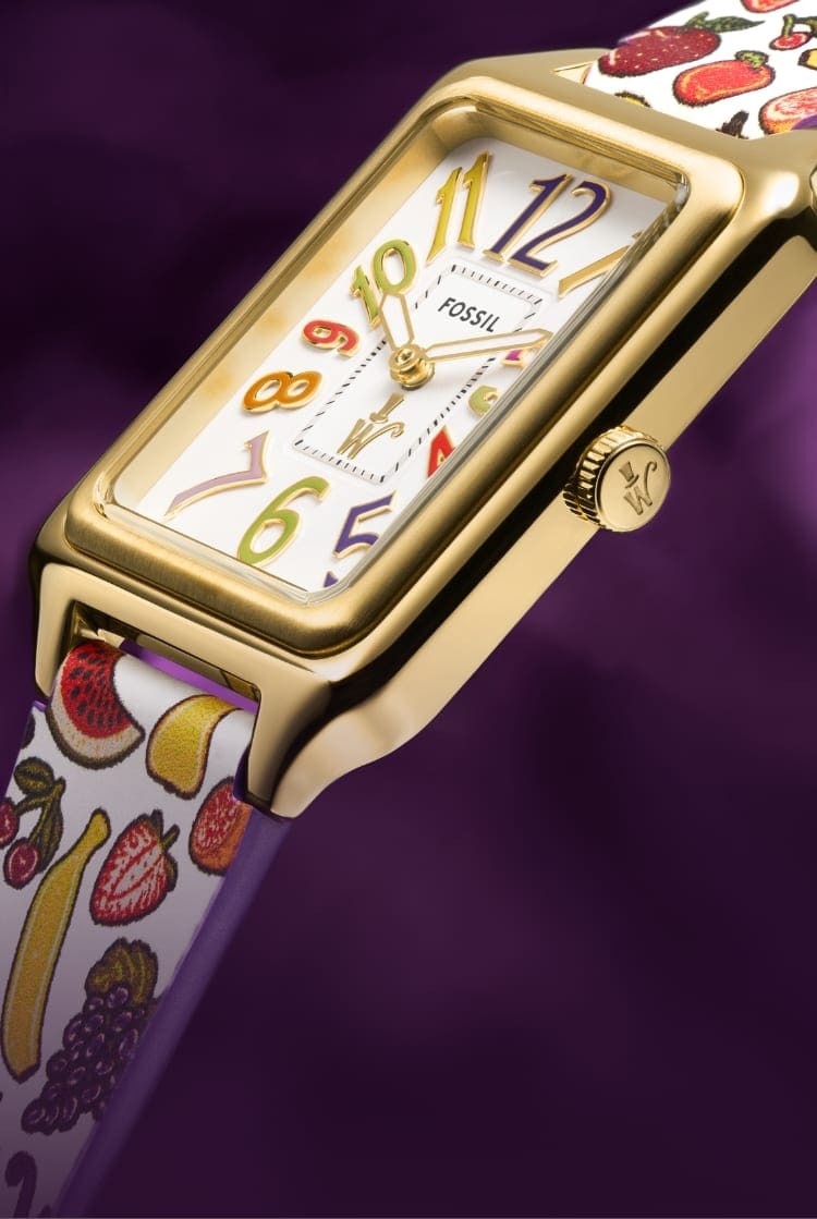 A gold-tone Raquel watch with a printed leather strap featuring fruit.