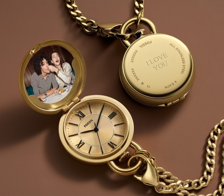 A gold-tone watch locket engraved with Since 12/11/12.