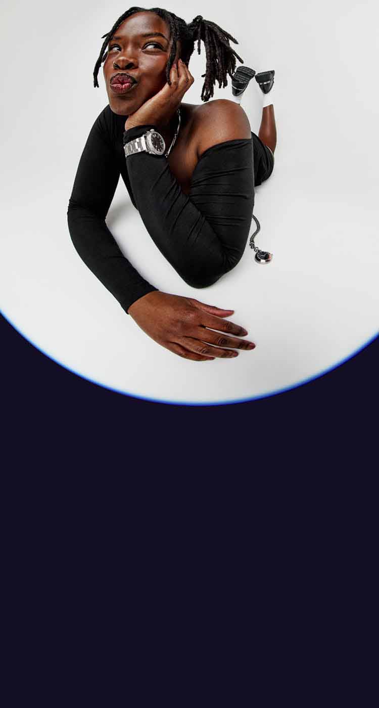 Woman playfully laying on the ground, wearing a Fossil watch.