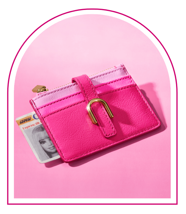 Ein pinker Hintergrund mit einem Fenster im Stil des Traumhauses von Barbie™. Im Fenster sieht man unser Limited Edition Barbie™ x Fossil Kartenmäppchen mit Reißverschluss im typischen Barbie-Pink mit goldfarbenen Beschlägen und originellem Colorblock-Design in verschiedenen Pinktönen innen.