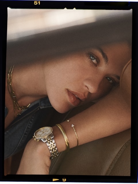 A woman wearing the Neutra Chronograph watch and gold-tone jewellery.