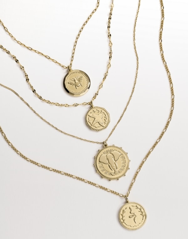 Four gold-tone pendant necklaces