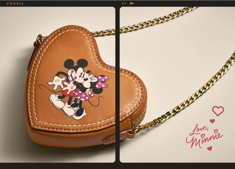 Este bolso de piel marrón en forma de corazón está rodeado por un ribete de tira de película, y luce un repujado de Mickey Mouse y Minnie Mouse en la parte delantera. En la esquina inferior izquierda, aparece Mickey Mouse sosteniendo un corazón rojo en las manos.