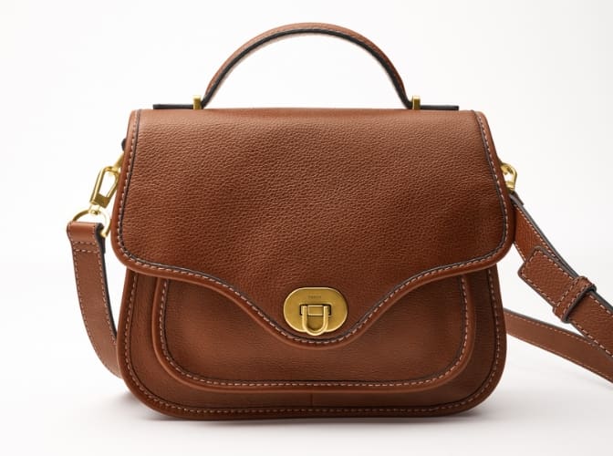 A hero shot of a brown leather Fossil Heritage top handle handbag.
