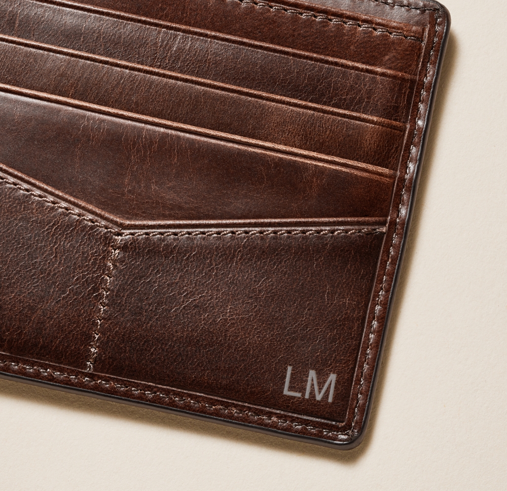 A brown leather wallet with LM embossed on it. 