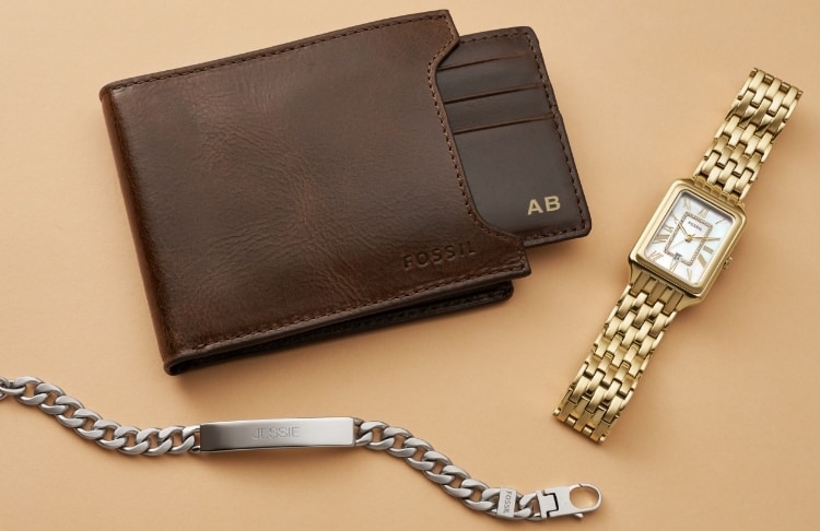 Un portefeuille en cuir marron marqué « AB » ; un bracelet en acier inoxydable gravé « ABC ». 