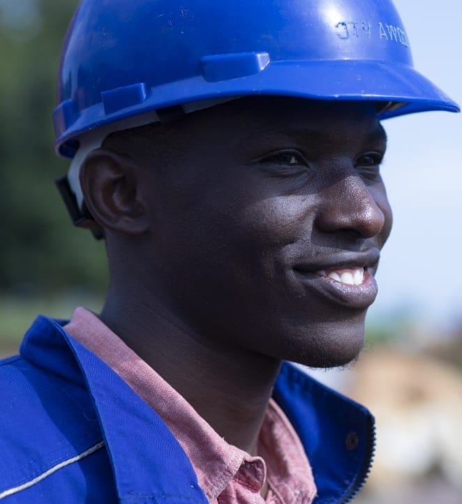 A young man wearing a construction hard hat.