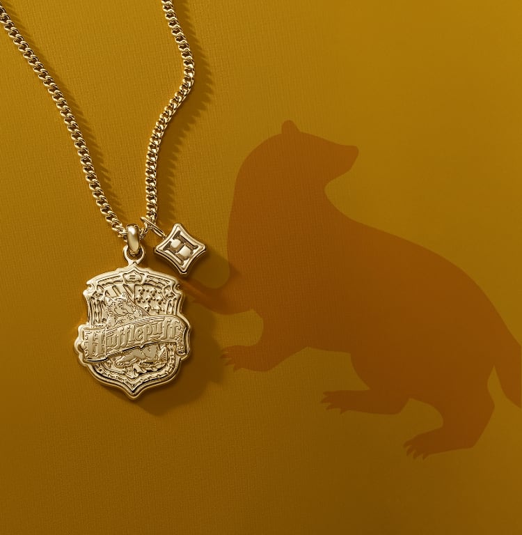 A gold-tone Hufflepuff house pendant.