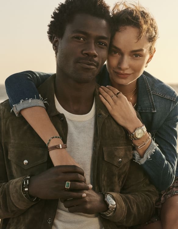 Pareja elegante abrazándose con joyas Fossil.