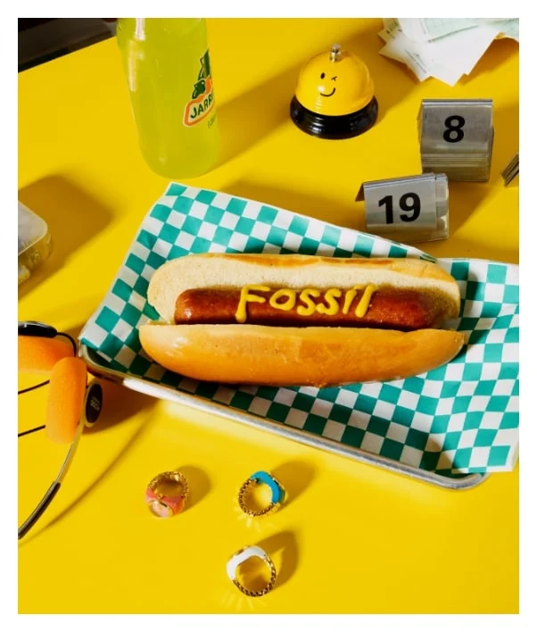 A hot dog with Fossil written in mustard.
