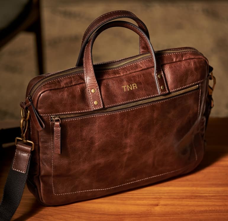 Sac en cuir brun avec initiales TNR embossées. 