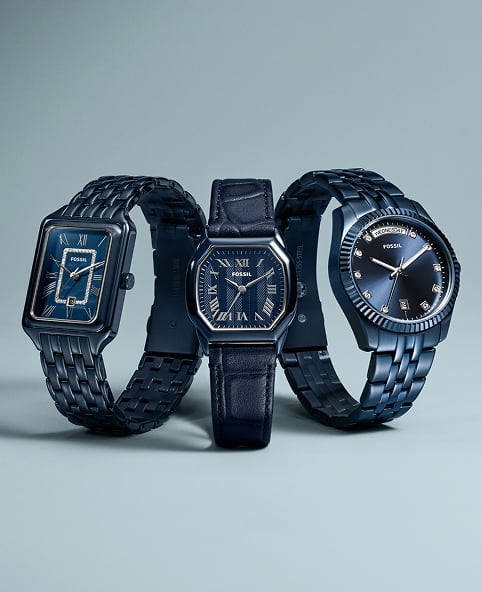 Three navy blue-toned Fossil watches – A Raquel, Harlow, and Scarlette – appear side-by-side on a light blue background.