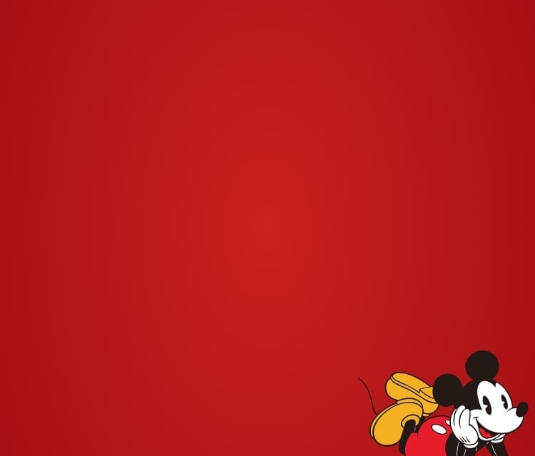Une bannière rouge avec une image de Mickey Mouse de Disney au coin inférieur gauche du cadrage, couché avec sa tête dans ses mains, souriant.