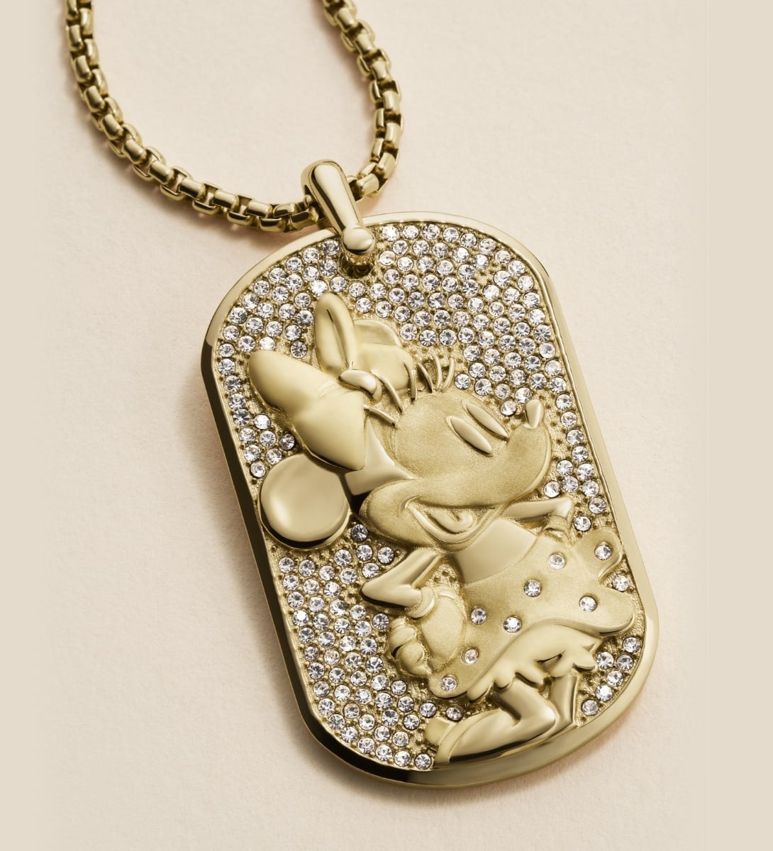 An animated GIF of two images. The first image features an all-black Mickey Mouse figurine pendant necklace studded with black hematite crystals. The second image showcases a gold-tone pendant of Minnie Mouse's profile, accented with crystals.