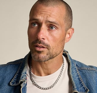 Un homme portant un collier chaîne argentée de style classique.