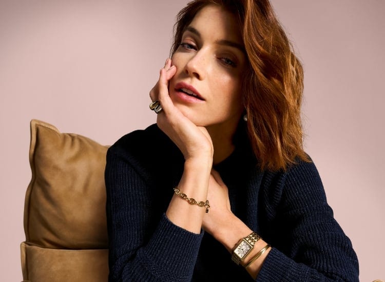 A woman wearing gold-tone Fossil jewellery and a gold-tone Raquel watch.