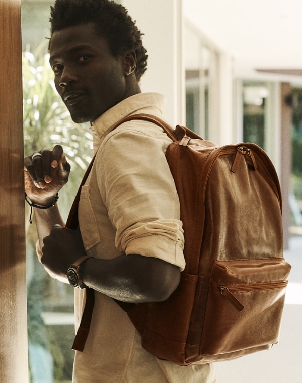 Un homme portant le sac à dos Buckner en cuir brun.