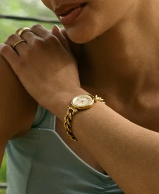 A lifestyle image of a woman crossing her arms, wearing the Carlie watch and a delicate bracelet.