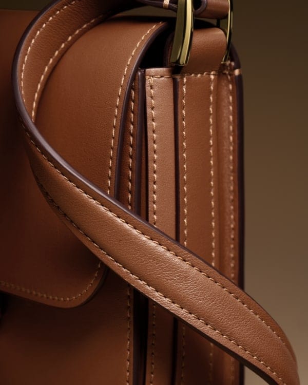 Il cinturino della borsa Lennox in pelle marrone con le cuciture.