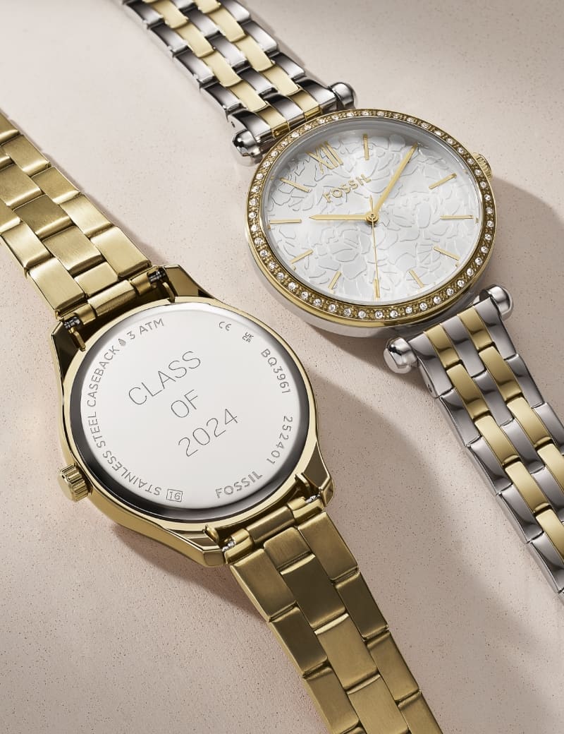 A gold-tone watch shown with an engraved message on the caseback: Class of 2024. It’s shown alongside a two-tone women’s watch featuring a sparkling topring and subtle floral texture on the dial.