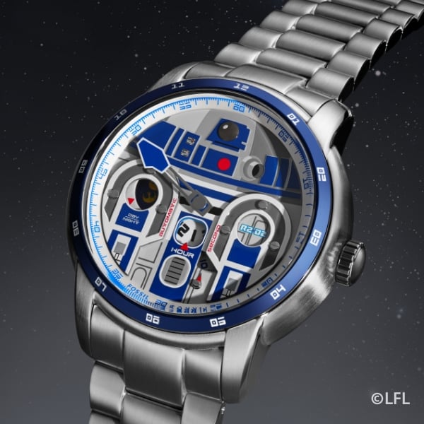 A close-up shot of a silver-tone watch with a dimensional appliqué of R2-D2 on the dial