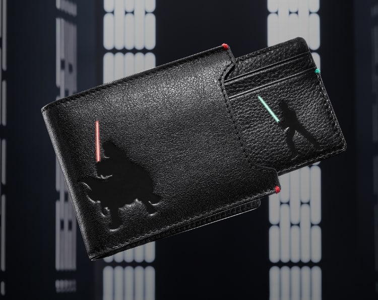 Un portafoglio nero con parte estraibile e goffrature raffiguranti Luke e Darth Vader 