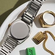 The caseback of a watch and necklace charm, waiting to be engraved.