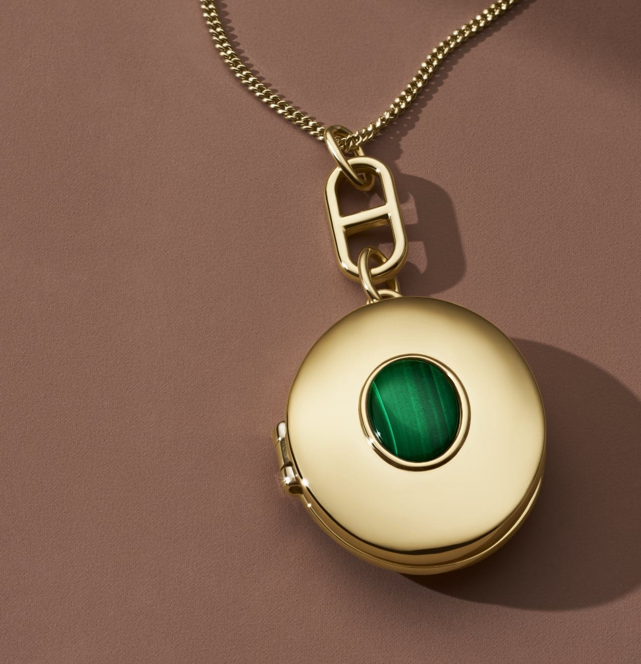 GIF of a gold-tone locket with malachite opening to reveal the photo inside.