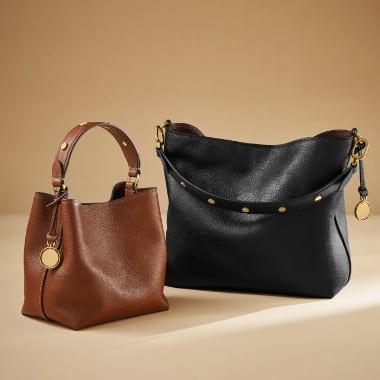 A brown leather and a black leather Jessie Bucket Bag.