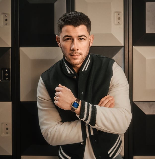 Singer, songwriter and actor Nick Jonas leans out of a vintage car wearing a denim jacket, white tee, and a limited-edition Machine Luxe watch from his exclusive collaboration with Fossil.