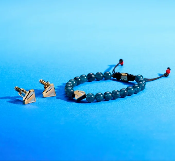 Blue beaded bracelet with Superman shield accent, shown with S-shield metal cuff links.