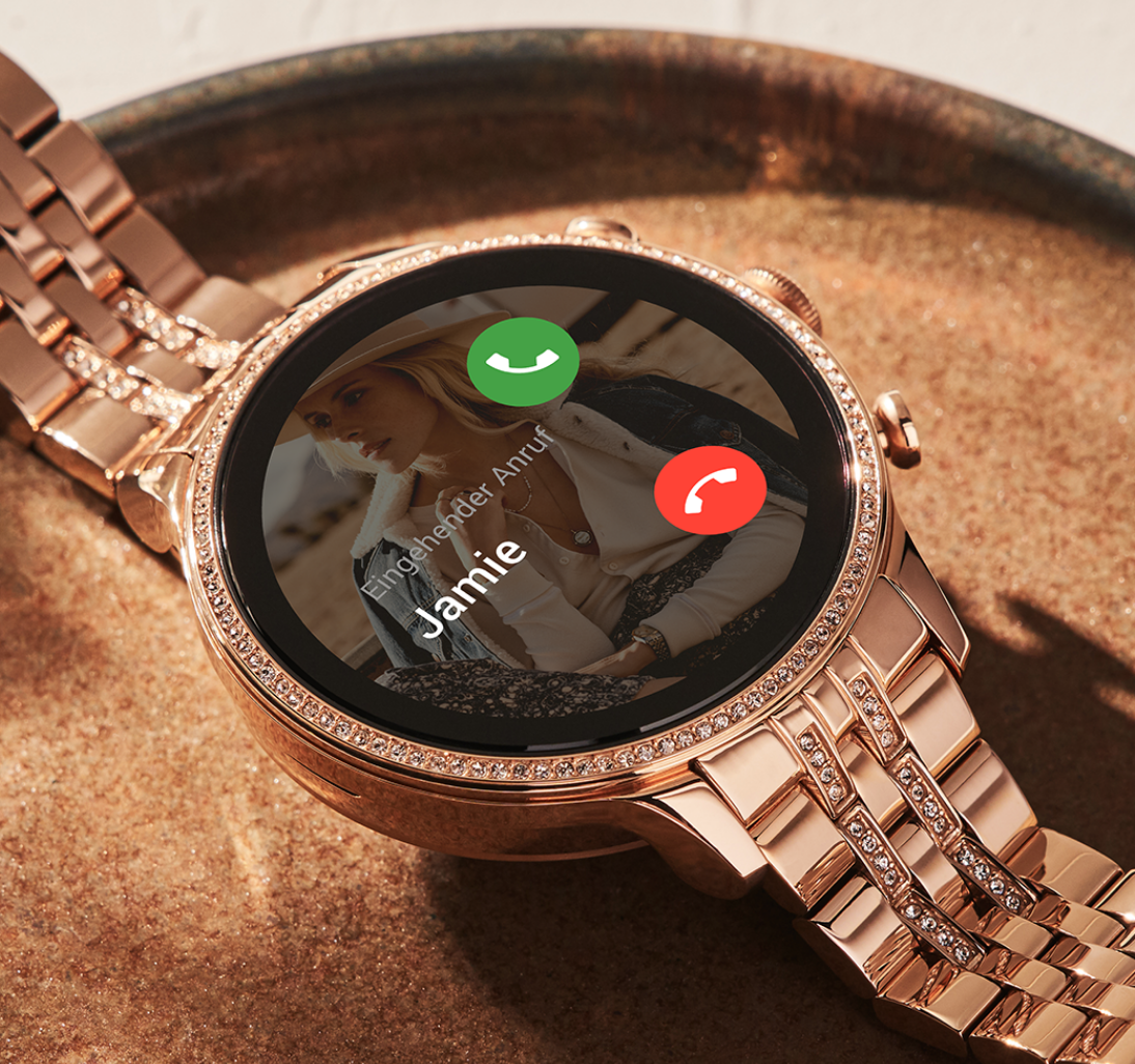 Eine Gen 6 Smartwatch aus roségoldfarbenem Edelstahl mit eingehendem Anruf auf dem Zifferblatt. Eine Gen 6 Smartwatch aus roségoldfarbenem Edelstahl mit eingehendem Anruf auf dem Zifferblatt.