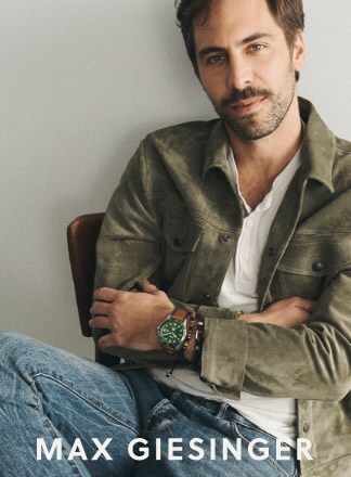 Max Giesinger sitting. He is wearing the Fossil Blue and the Fossil leather and beads bracelets.
